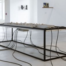 Stefano Caimi, Lithochronos, 49x56x200 cm, pietre, elettrovalvole, cavi, ferro, arduino, legno sbiancato, 2024
